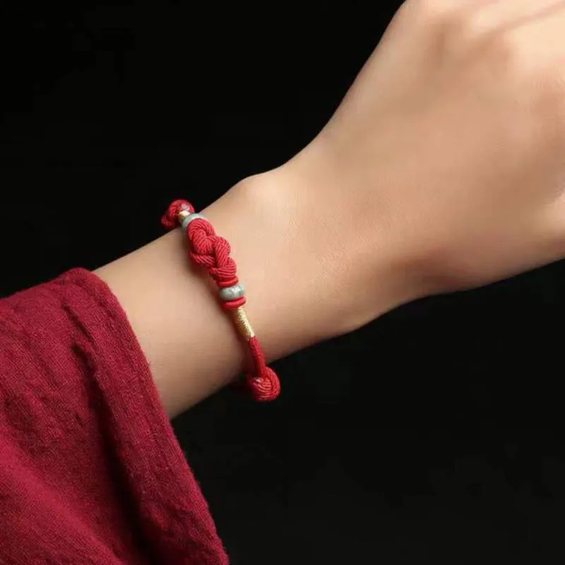Hand-knotted red string bracelet worn on wrist